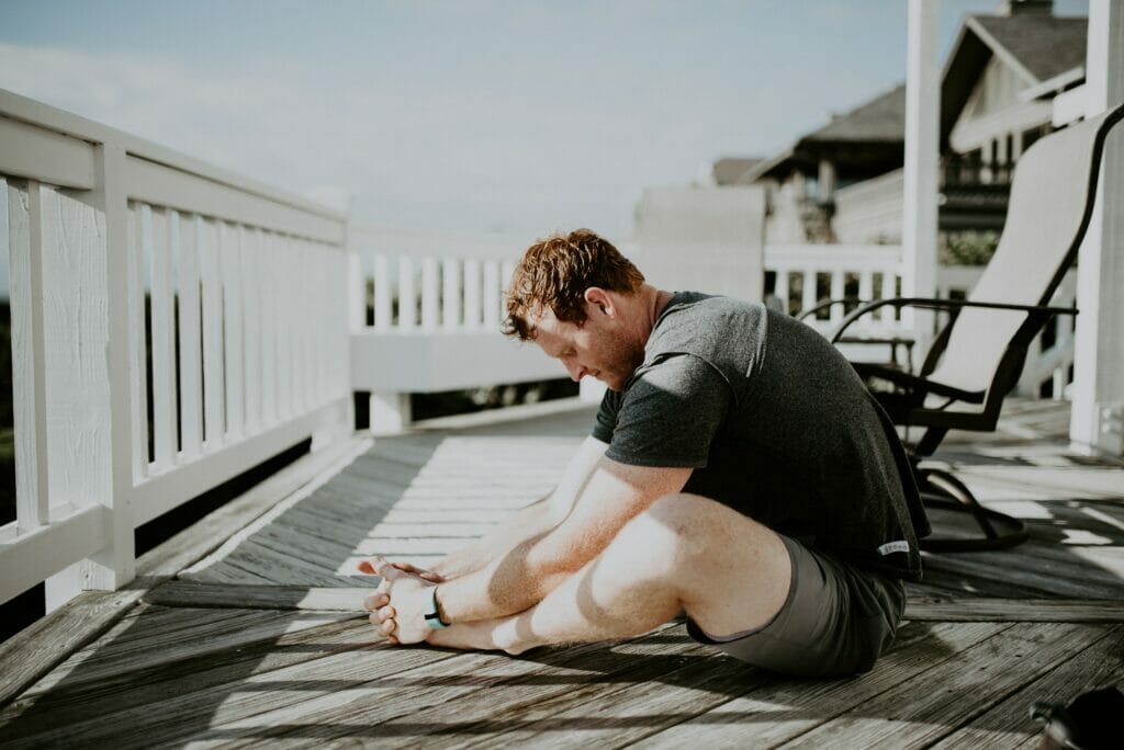 man doing yoga outside a caravan